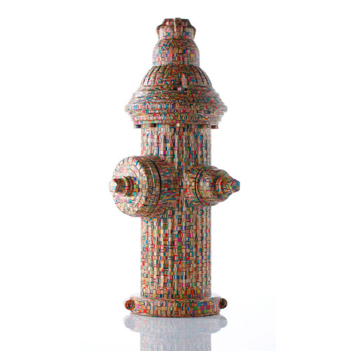 A fire hydrant sculpture made entirely from laminated, colorful recycled skateboard deck cross-sections, set against a clean white background.
